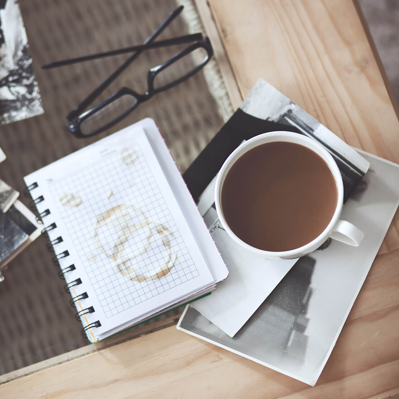 A cup of coffee and some glasses on the table.