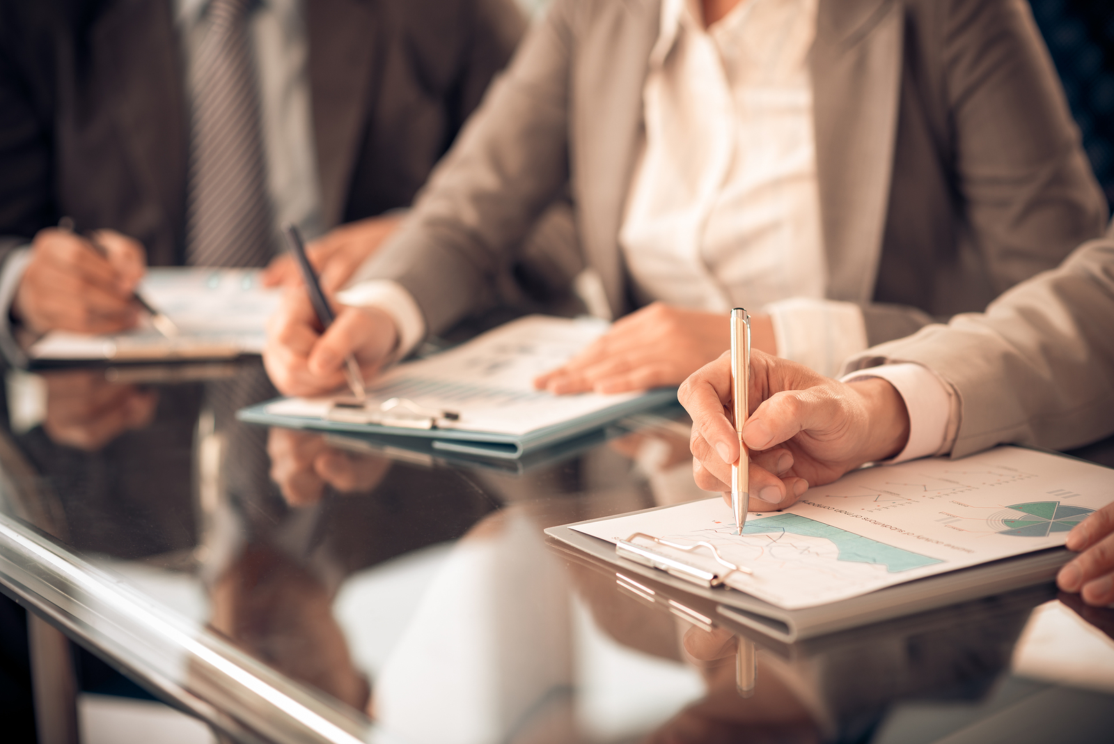 A group of people sitting at a table with papers.