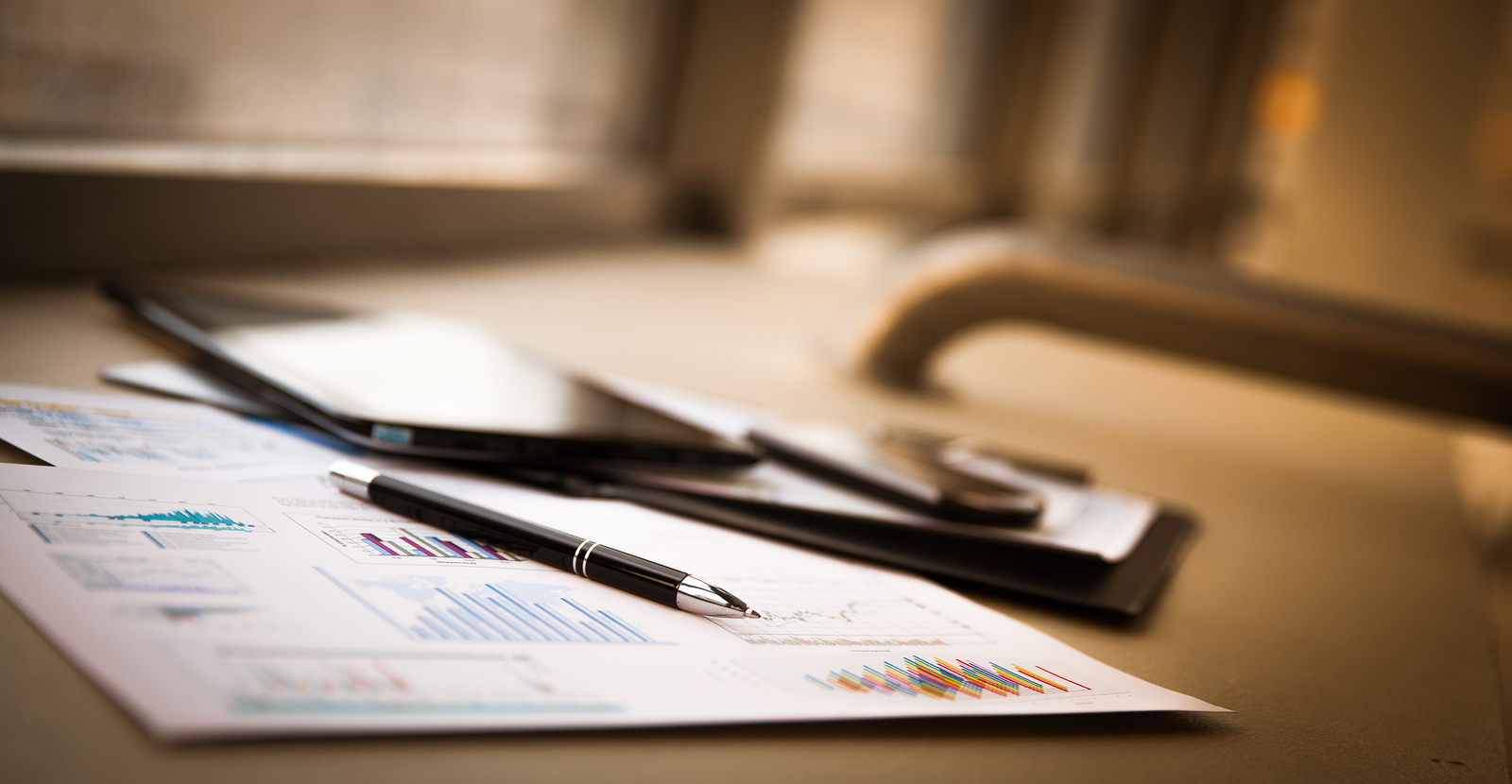A pen and some papers on top of a table.